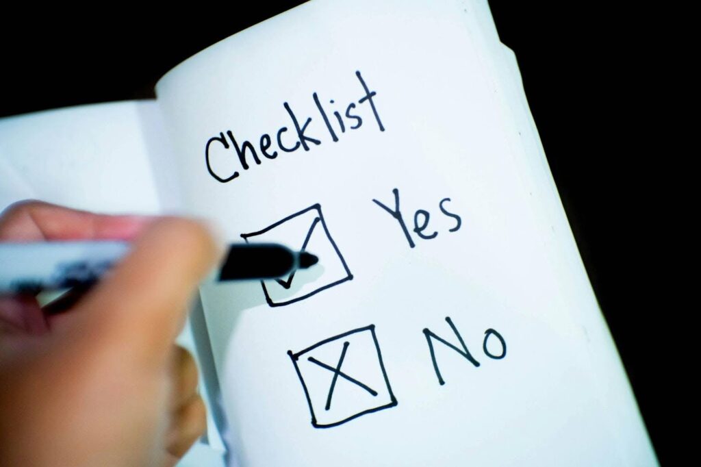 a yes and no checklist on a piece of paper a person is marking the box for yes